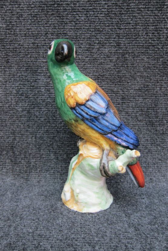 Фарфоровая статуэтка попугая, сидящего на пеньке